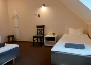 a room with two beds and a chair in it at Aiakeskuse hostel in Rakvere