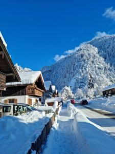 a street covered in snow with cars driving down it at Alpenwohnung "Zum Schorschi" mit Bergblick I voll ausgestattet I ruhige Lage in Oberammergau