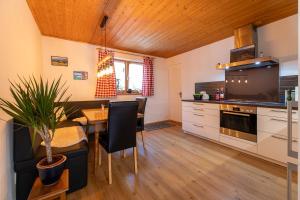 a kitchen with a table and a dining room at Alpenwohnung "Zum Schorschi" mit Bergblick I voll ausgestattet I ruhige Lage in Oberammergau