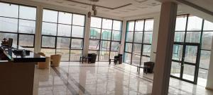 a large room with windows and tables and chairs at Hôtel Kolou Wyam in Tcharé +219 photos