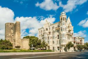 a large white building with a tower on a street at Retro Silent Boutique Hotel in Baku