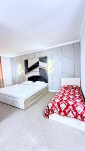 a bedroom with a bed with a red and white comforter at Sultan Saray in Türkistan