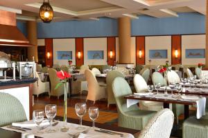 um restaurante com mesas e cadeiras com copos de vinho em Pestana Porto Santo Beach Resort & SPA em Porto Santo