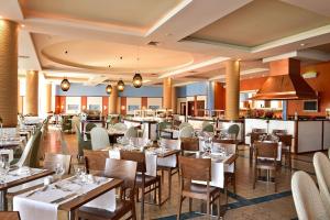 ポルト・サントにあるPestana Porto Santo Premium All Inclusive Beach & SPA Resortのテーブルと椅子とバーのあるレストラン