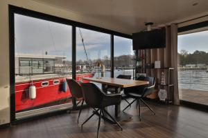 a dining room with a wooden table and a red boat at Wasservilla freiZeit Usedom in Peenemünde +14 photos