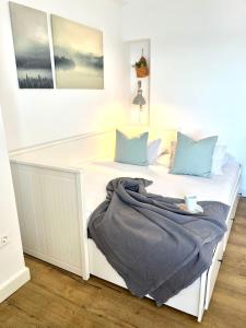 a white bed with blue pillows and a blanket on it at Studio on the Beach Front in Sitio de Calahonda +47 photos