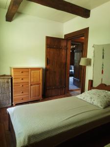 a bedroom with a bed and a wooden dresser at Chata Balówka in Cisna