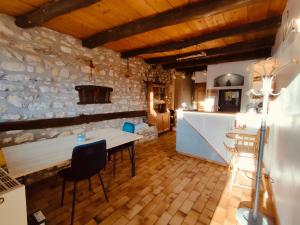 a kitchen with a table and chairs in a room at L'Horizon - Maison en Pierres, Vue Alpes et Nature in La Burbanche