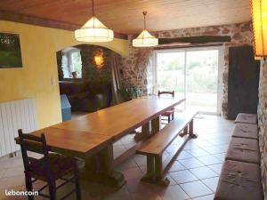 a large wooden table with benches in a room at Gîte de la chanal 07 in Villevocance