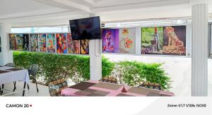 a room with a table and a tv on a wall at Hôtel Kolou Wyam in Tcharé