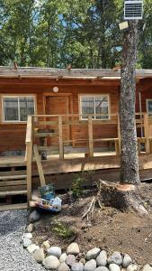 a log cabin with a tree in front of it at Rukas Huinkaray in Pucón