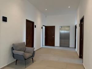 a living room with a chair and two doors at MIRAMARE Ocean View in Puerto Morelos
