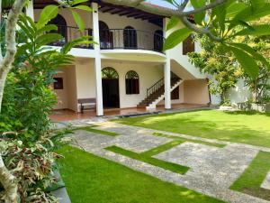 a house with a green lawn in front of it at THC - Tropical Hideaway Ceylon in Talpe +19 photos