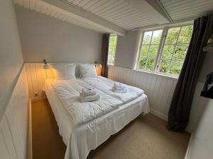 a bedroom with a white bed with towels on it at Pensionat Næsgaarden in Allinge