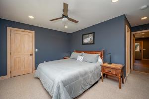 a blue bedroom with a bed and a ceiling fan at Chubby Bunny Lodge by Railey Vacations in McHenry +43 photos