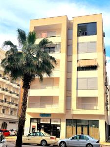 a palm tree in front of a building at Appartament ZEA in Durrës
