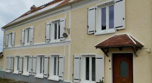 a building with white windows and a door at La Briarde chambre d'hôtes double seule in Boissy-le-Châtel