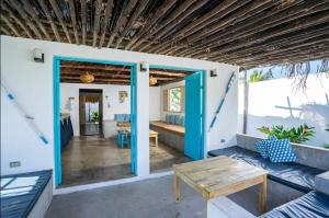 a porch with a blue door and a table at El Paredon Beach, Casa Yemanja in El Paredón Buena Vista