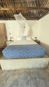 a bed in a bedroom with a blue and white comforter at El Paredon Beach, Casa Yemanja in El Paredón Buena Vista +27 photos