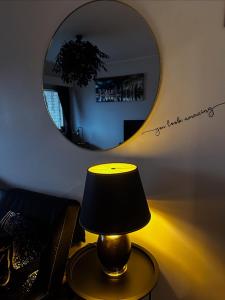 a lamp on a table in front of a mirror at Lemmenpesä Ytimessä in Oulu +13 photos