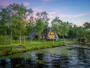 a house in the woods next to a river at Lake Bomoseen - Lake Access, Fire Pit & BBQ in Castleton