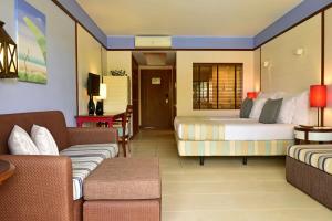 ポルト・サントにあるPestana Porto Santo Premium All Inclusive Beach & SPA Resortのベッド2台とソファがあるホテルの部屋