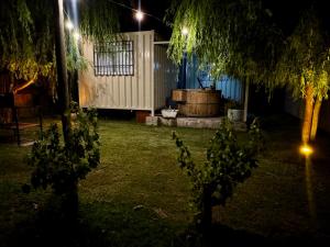a yard lit up at night with a barrel at KooColand- Container con jacuzzi privado in Tupungato
