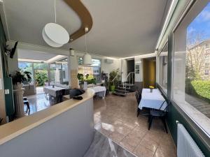 a kitchen and dining room with tables and chairs at Hôtel Au Val De Saône PARKING GRATUIT in Sathonay-Camp