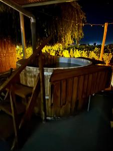 a hot tub in a backyard with a wooden fence at KooColand- Container con jacuzzi privado in Tupungato