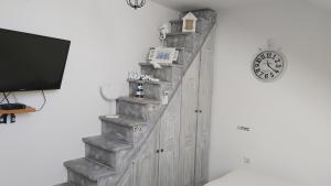 a room with a staircase with a clock on the wall at Rooms GRIZZLY in Slunj