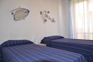 um quarto com 2 camas e um espelho na parede em Da Nino e Maria em Marina di Modica