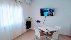 a dining room with a white table and white chairs at Monoambiente luminoso impecable in Bahía Blanca +3 photos