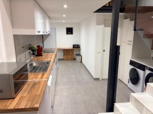 a kitchen with white cabinets and wooden counter tops at LOFT La Palma in Almería +10 photos