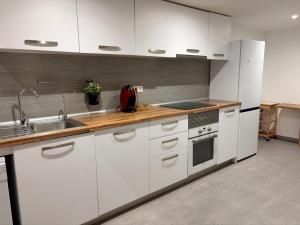 a kitchen with white cabinets and a sink at LOFT La Palma in Almería