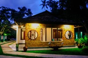 a small brick house with lights on it at Nature Forest Villa in Hikkaduwa