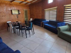 a living room with a couch and a table and chairs at Cabañas de Turismo Berolav7 in Puerto Montt