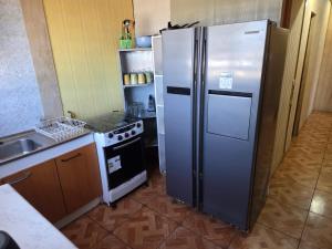 a kitchen with a stainless steel refrigerator and an oven at Cabañas de Turismo Berolav7 in Puerto Montt