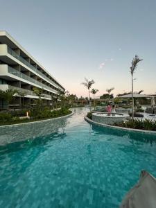 a swimming pool in front of a hotel at Flat Premium Muro Alto-conforto a 150m do mar in Ipojuca