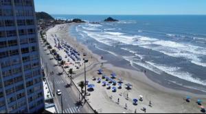 a view of a beach with umbrellas and the ocean at Praia dos Sonhos - Suítes in Itanhaém