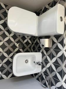 a white sink in a bathroom with black and white tiles at Al Amoreirinha Rui Barata in Castelo Branco +23 photos