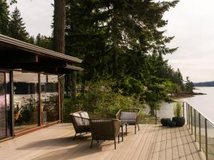 a deck with chairs and a table with a view of the water at The Bald Seagle in Port Orchard