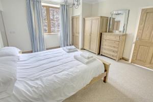 a bedroom with a large white bed and a dresser at 1 Bed in Seaton oc-mbsov in Seaton