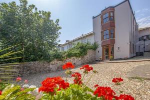 a garden with red flowers in front of a building at 1 Bed in Seaton oc-mbsov in Seaton