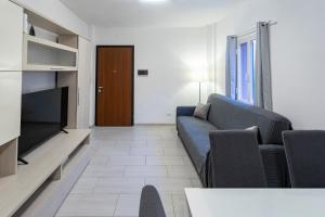 a living room with a blue couch and a television at Casa Cesari in Ponte Ronca
