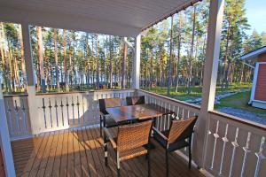 a screened porch with a table and chairs on it at Ruoke Holiday Village in Kesälahti
