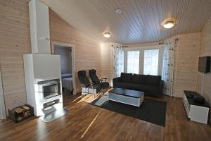 a living room with a couch and a fireplace at Ruoke Holiday Village in Kesälahti