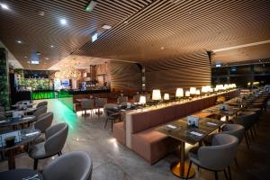 a restaurant with tables and chairs and a bar at Allure Hotel & Spa in Eger