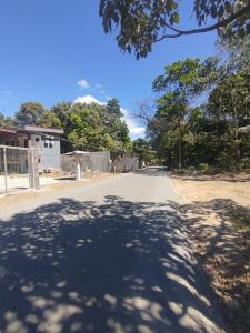 an empty street with a tree shadow on the road at Las Morenas in Nosara