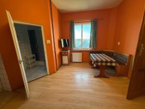 an orange room with a couch and a window at Noclegi pracownicze Mitarbeiterunterkünfte Employee accommodation in Chojna