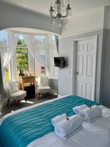 a bedroom with a large bed with a blue blanket at Bentley Lodge in Torquay